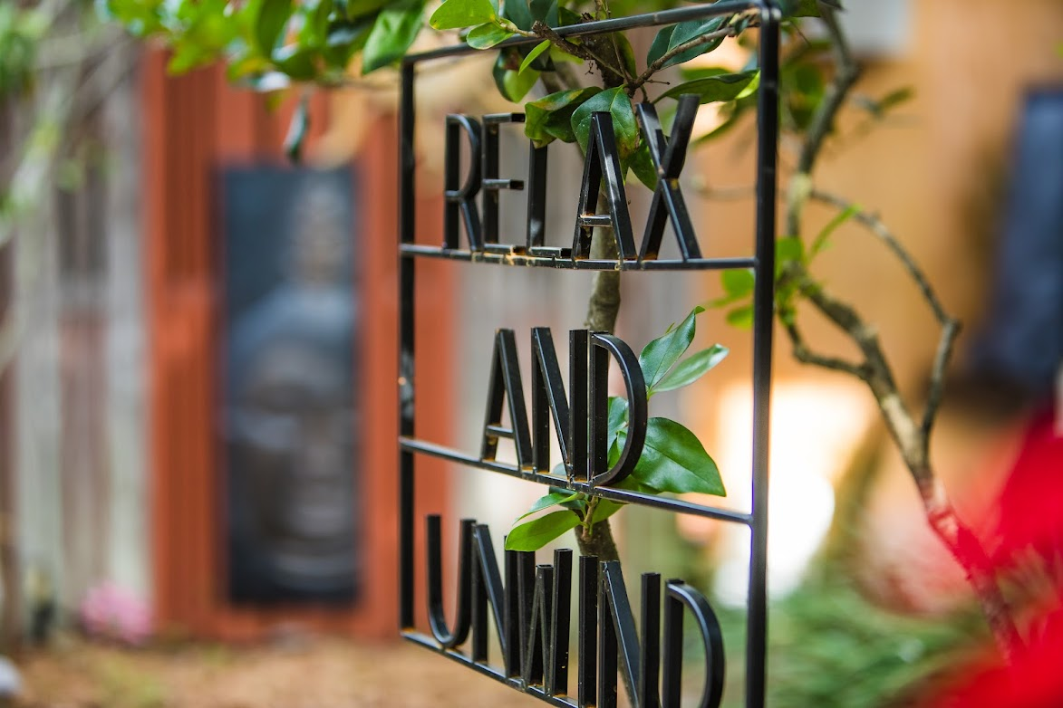 Relax and Unwind metal sign in the bungalow's garden courtyard